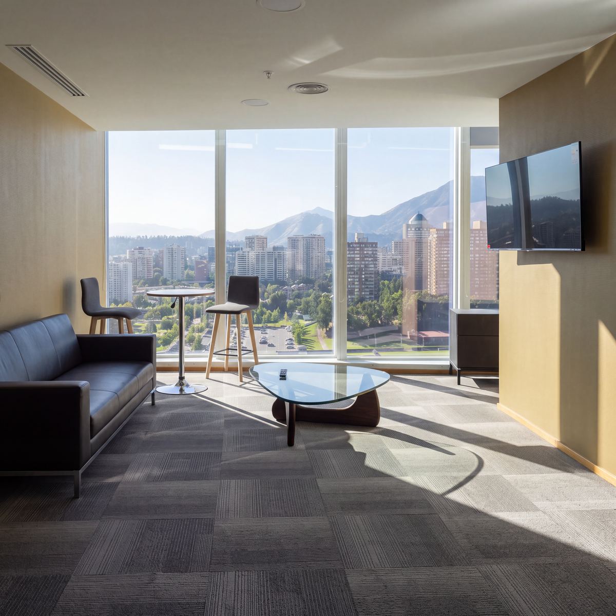 Sala de estar de oficinas de Banco Itaú con alfombra modular y vista a la cordillera